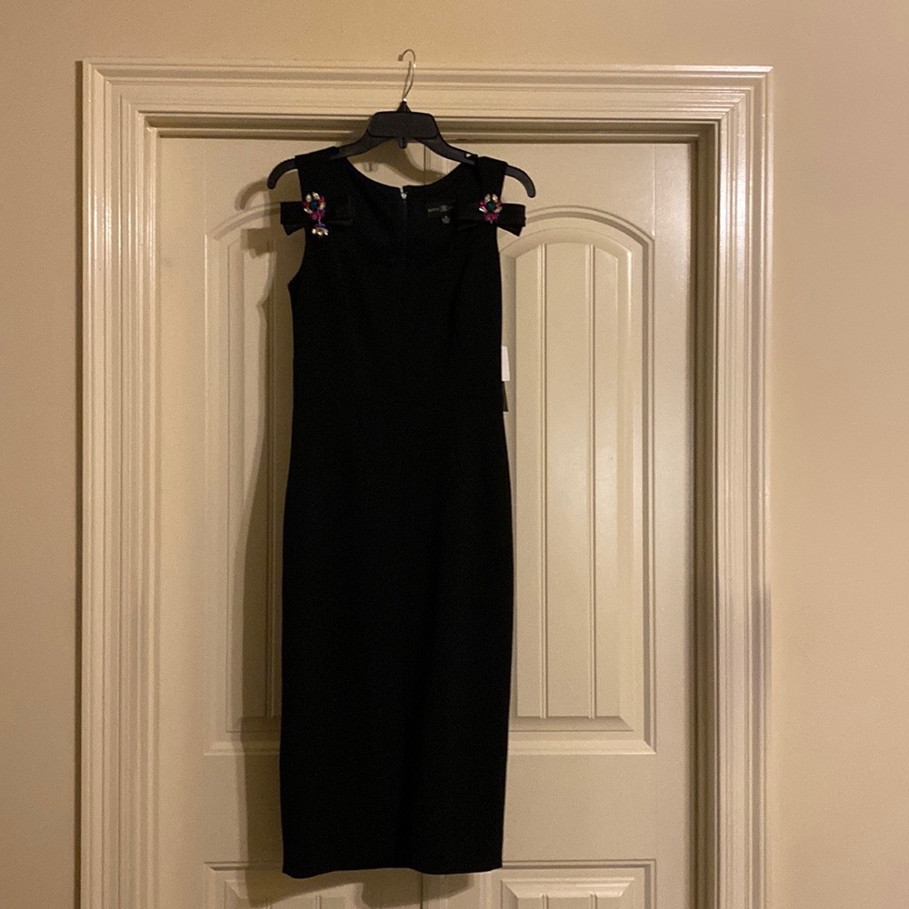 Black sleeveless dress that boasts satin bejeweled front bows.